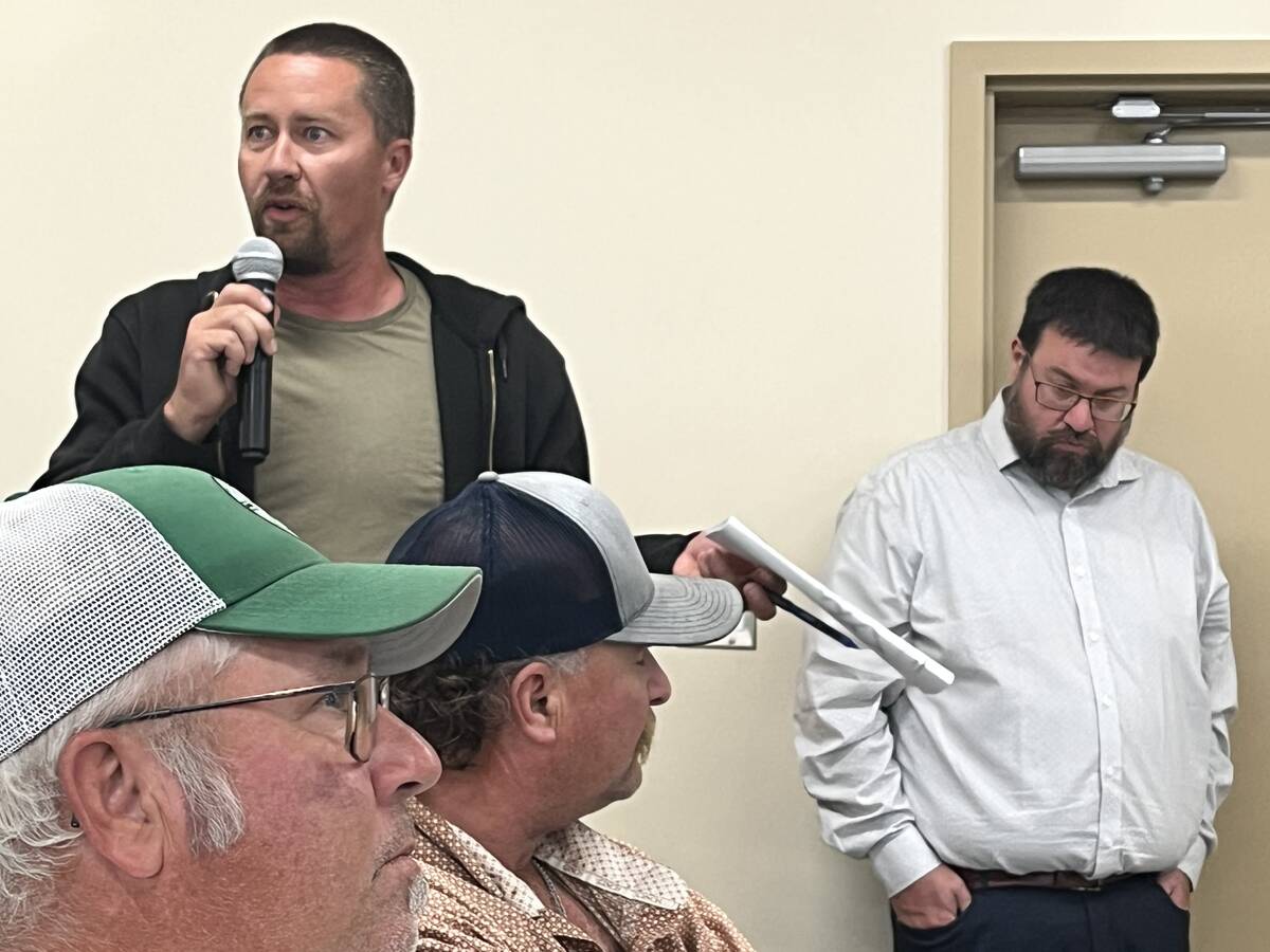 Chris Siemens speaks into a microphone at a public meeting about grazing lease policies in the M.D. of Taber. Photo: Greg Price
