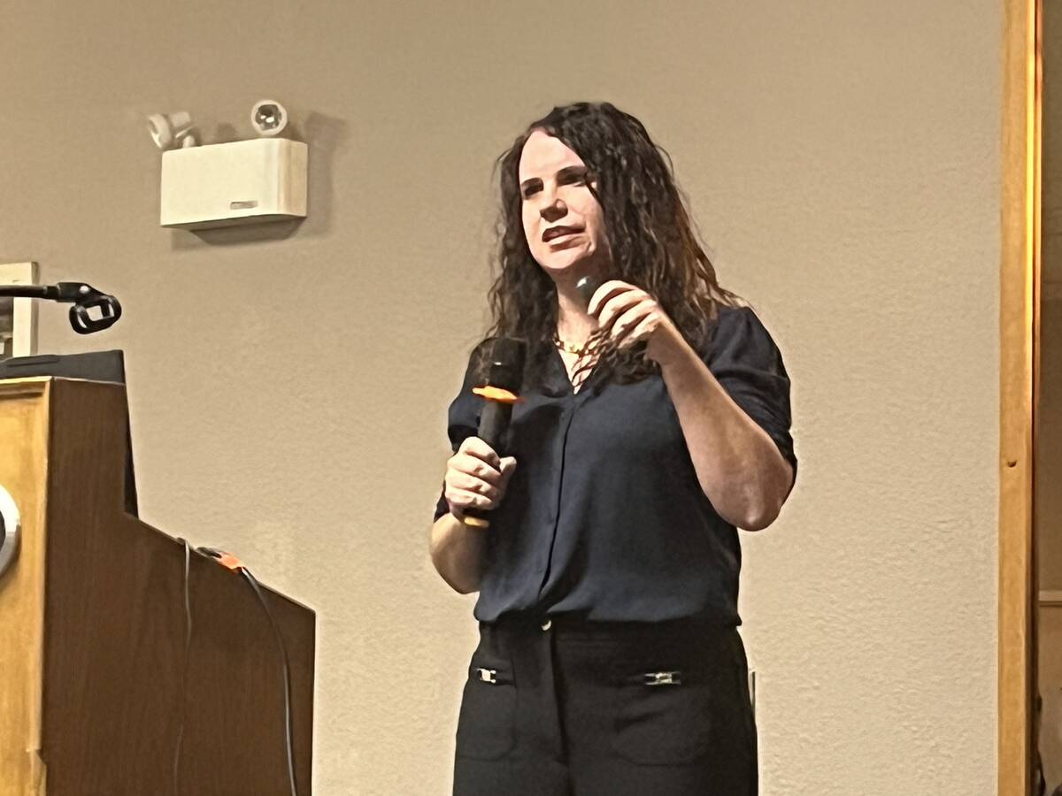 Stacey Bajema, government relations and policy director for Potato Growers of Alberta, holds a microphone while addressing the south regional meeting in Taber, Alta. Photo: Greg Price