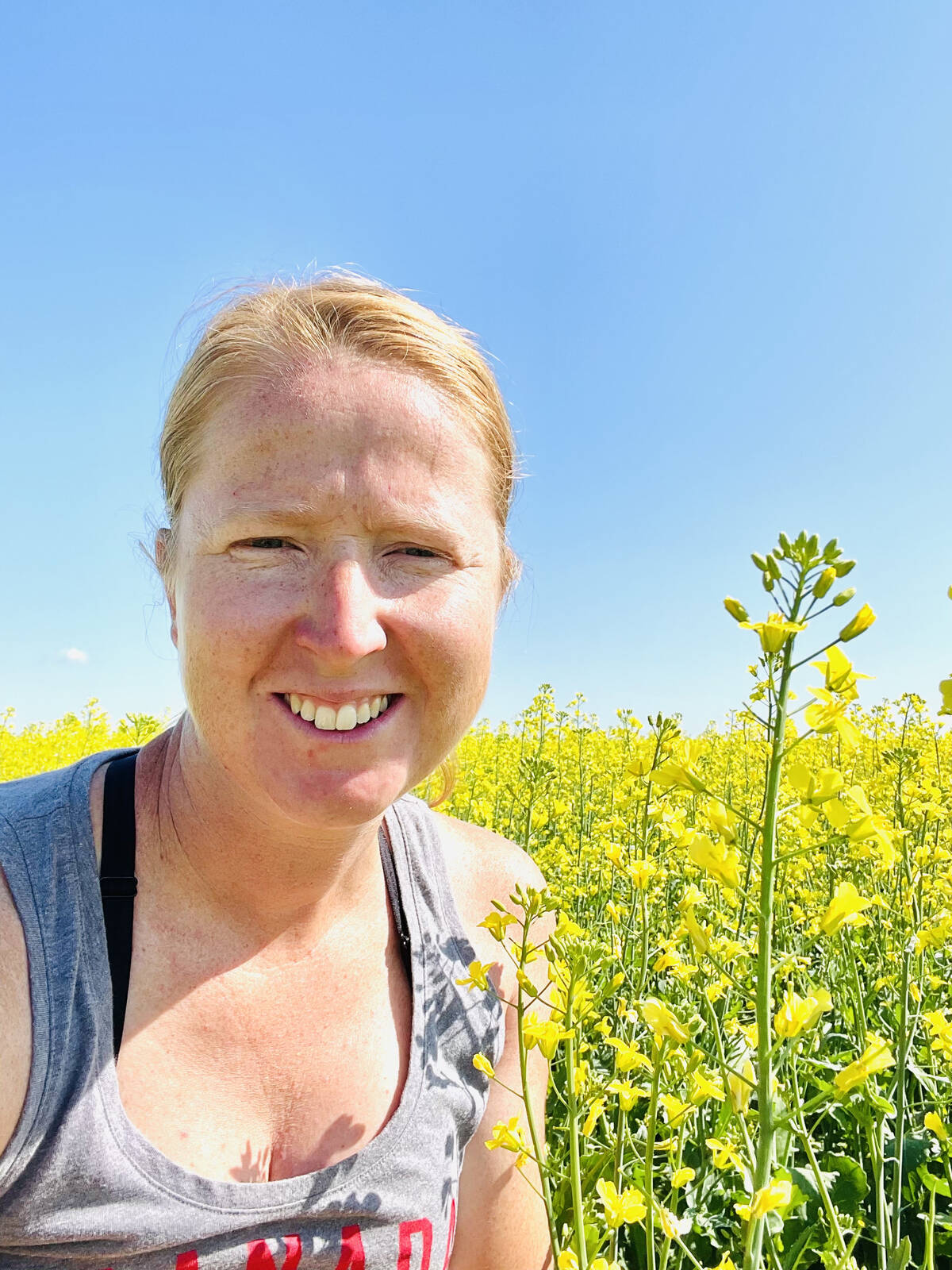 Cheryl Westman, an agronomist who operates a mixed farm near Vermilion, standing in a canola field in bloom. Westman has questions about who will be involved in developing the new National Agricultural Soil Health Strategy.
Photo: supplied