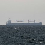 A large cargo vessel seen through haze on open water in the Strait of Hormuz. Photo: Reuters