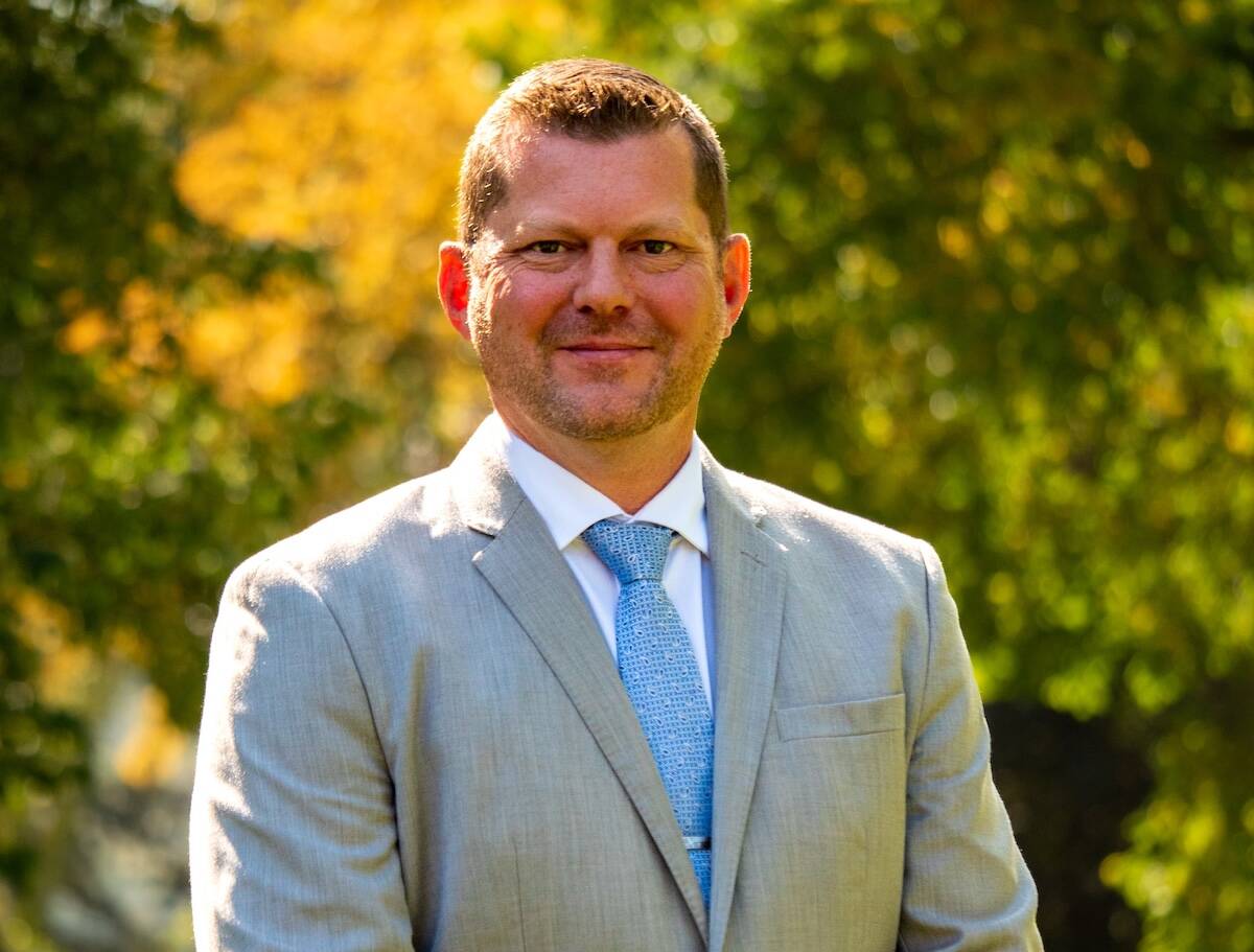 RJ Sigurdson, Minister of Alberta Agriculture and Irrigation, photographed outdoors in a suit against a backdrop of autumn foliage. Photo: Supplied
